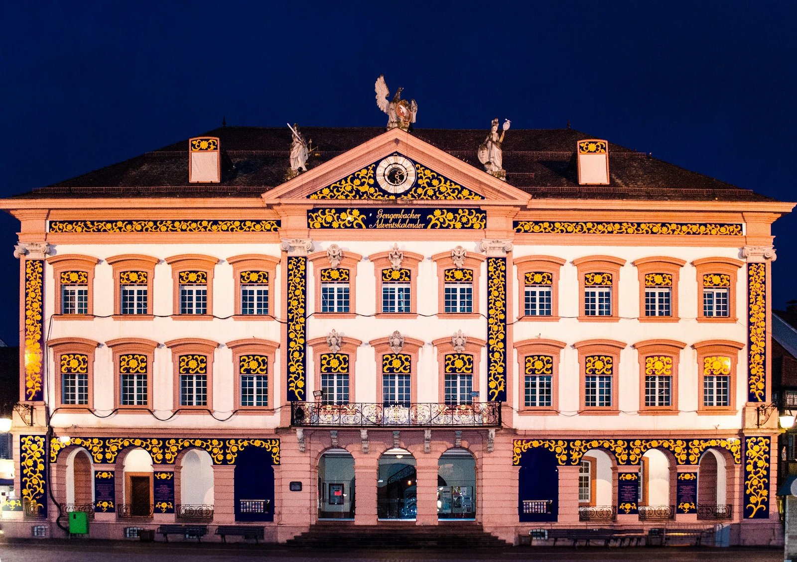 Rathaus in Gengenbach als Adventskalender, abends beleuchtet mit goldenen Ornamenten auf blauem Grund